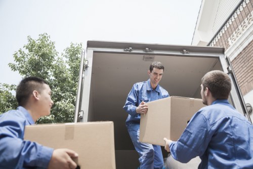Packed moving boxes and furniture ready for transport in Cannhall