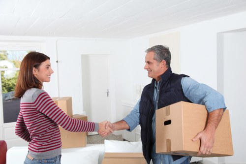 Professional movers carrying furniture in a Cannhall apartment building